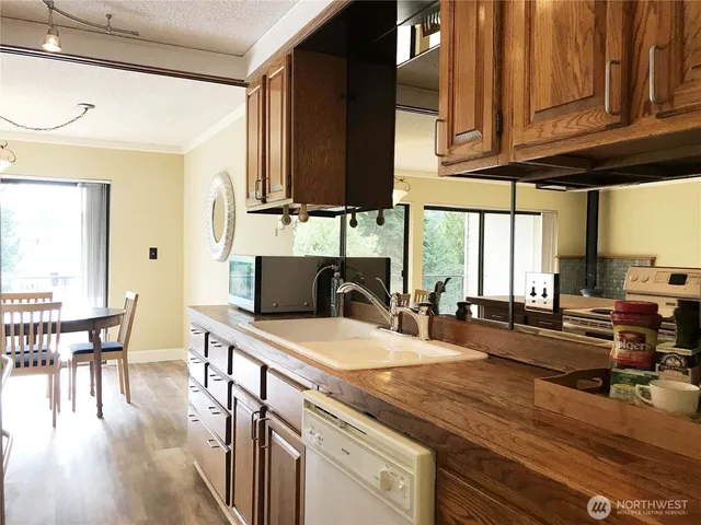 a kitchen with stainless steel appliances granite countertop a sink a stove and cabinets