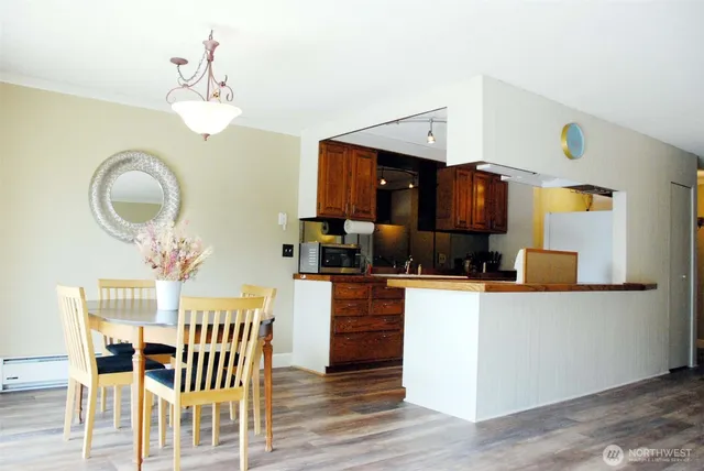 a kitchen with granite countertop a table chairs stove and cabinets