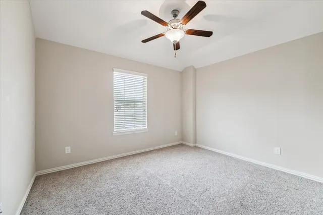 an empty room with a window and a fan