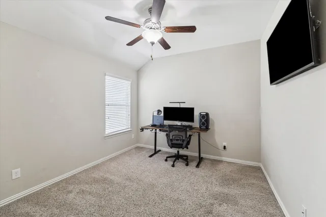 a view of a workspace with furniture and a window