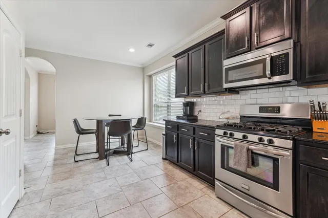 a kitchen with stainless steel appliances granite countertop a stove microwave and sink