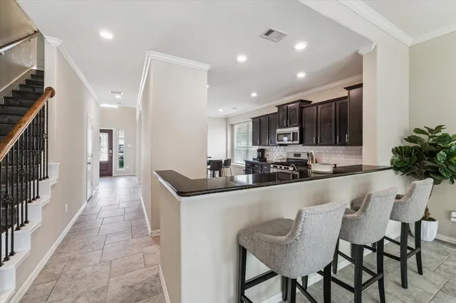 a kitchen with stainless steel appliances granite countertop a sink and a refrigerator