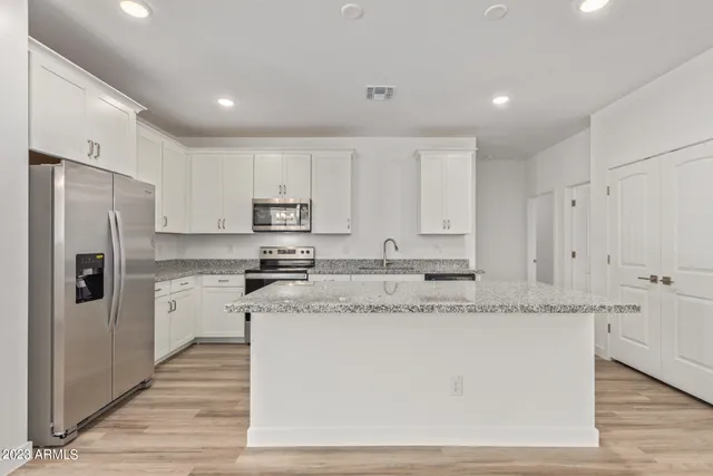 a kitchen with granite countertop cabinets stainless steel appliances and a counter space