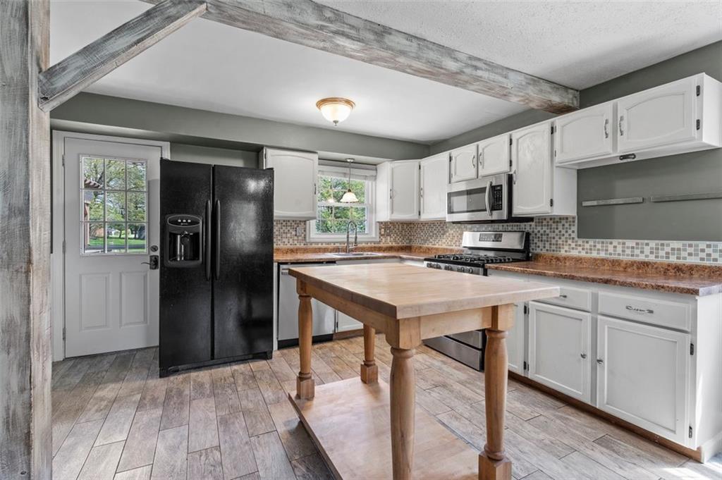 424 Thompson Run Road Pittsburgh, PA 15237 - Photo 7 of 31 a kitchen with kitchen island granite countertop a stove a sink and a refrigerator with wooden floor