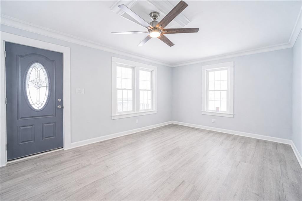 671 Old Rte 8 Harrisville, PA 16038 - Photo 13 of 49 an empty room with wooden floor a ceiling fan and a window