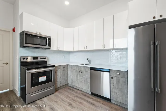 a kitchen with stainless steel appliances granite countertop a stove a refrigerator and a microwave