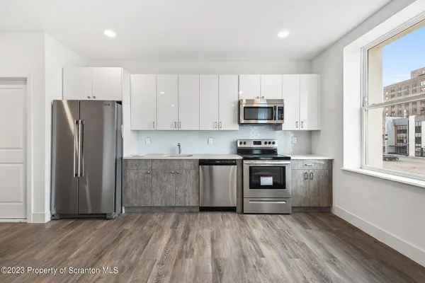 a kitchen with granite countertop a refrigerator and a stove top oven