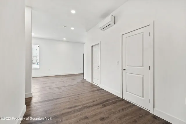 a view of an empty room with wooden floor