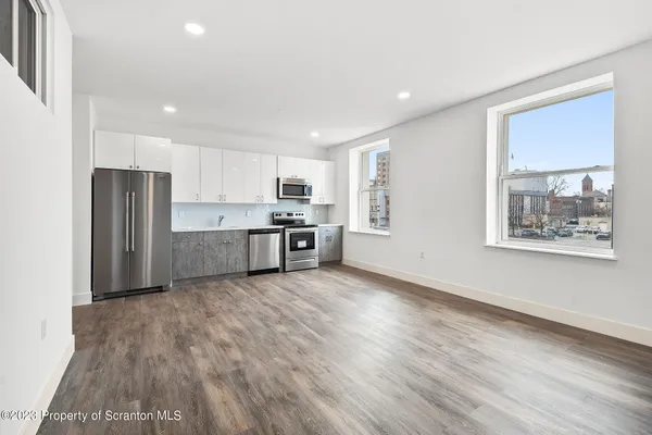 a large kitchen with stainless steel appliances granite countertop a refrigerator and a stove top oven