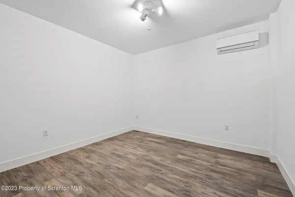 a view of a room with wooden floor and white walls