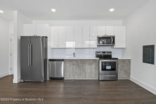 a kitchen with a refrigerator and a stove top oven