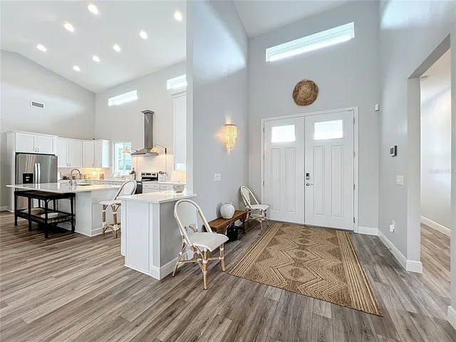 a kitchen with sink refrigerator dining table and chairs