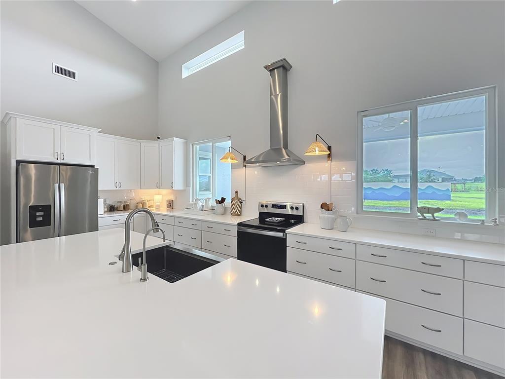 10220 Bay Lake Road Groveland, FL 34736 - Photo 12 of 90 a kitchen with stainless steel appliances a stove a sink and a refrigerator