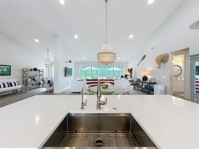 a living room with furniture a flat screen tv and kitchen view