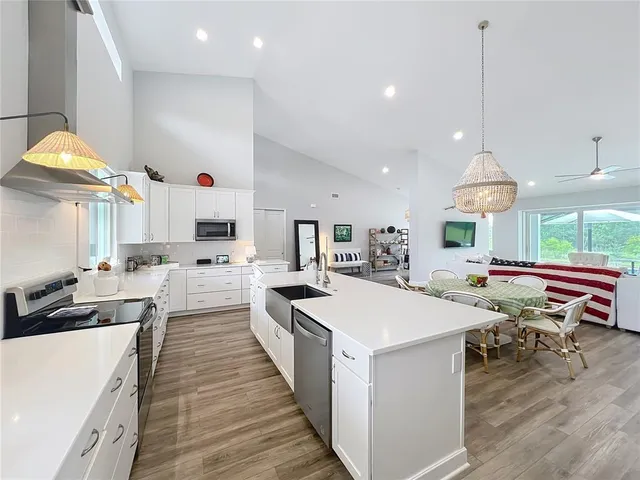 a living room with furniture a flat screen tv and kitchen view