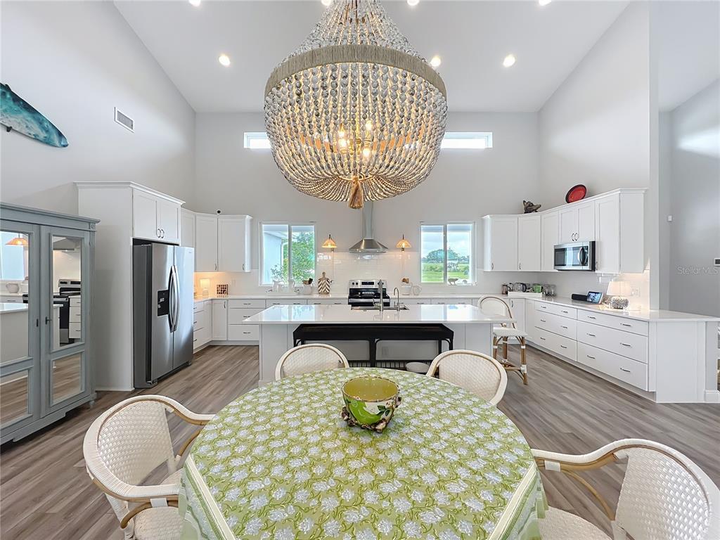 10220 Bay Lake Road Groveland, FL 34736 - Photo 19 of 90 a kitchen with sink refrigerator dining table and chairs