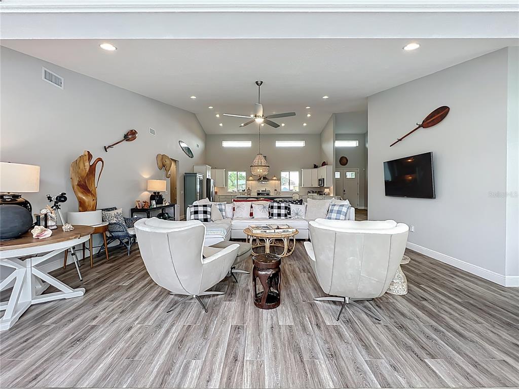 10220 Bay Lake Road Groveland, FL 34736 - Photo 24 of 90 a living room with furniture a flat screen tv and kitchen view