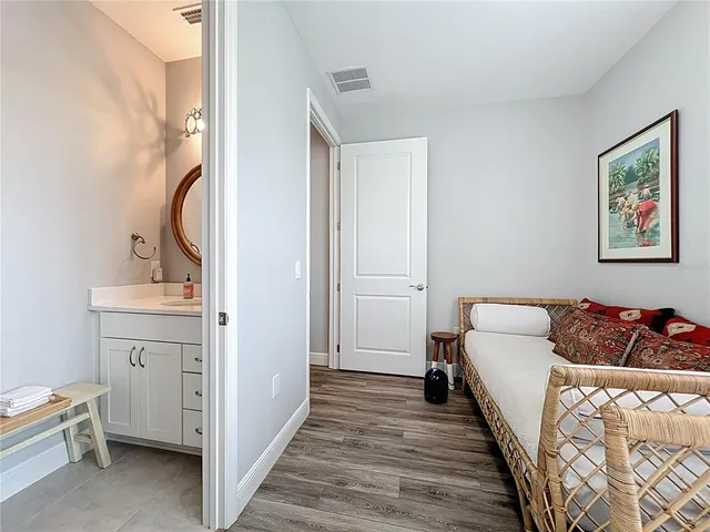 a spacious bedroom with a bed and wooden floor