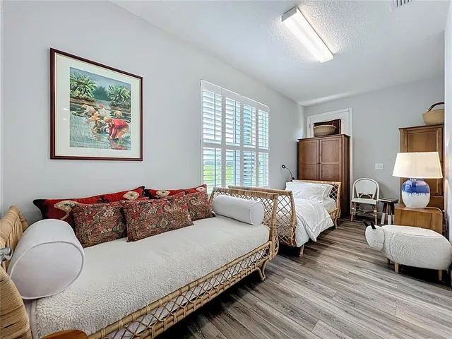 a bedroom with a bed and a flat tv screen on dresser