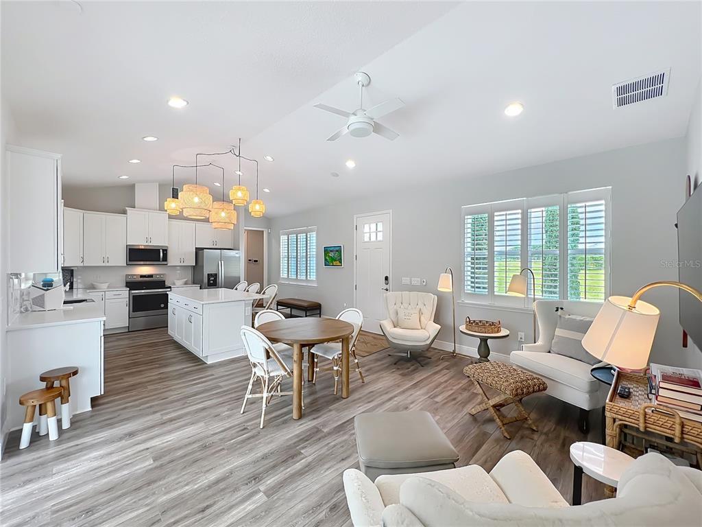 10220 Bay Lake Road Groveland, FL 34736 - Photo 62 of 90 a living room with furniture kitchen view and a wooden floor