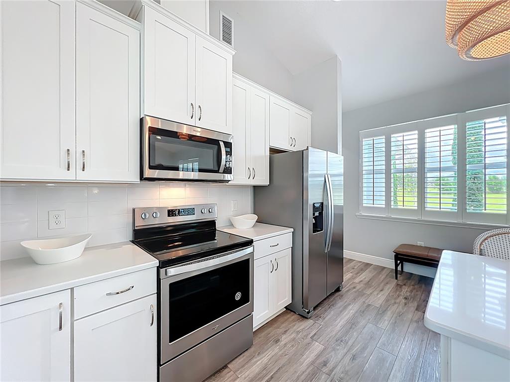 10220 Bay Lake Road Groveland, FL 34736 - Photo 65 of 90 a kitchen with stainless steel appliances a stove a sink dishwasher a refrigerator microwave and cabinets