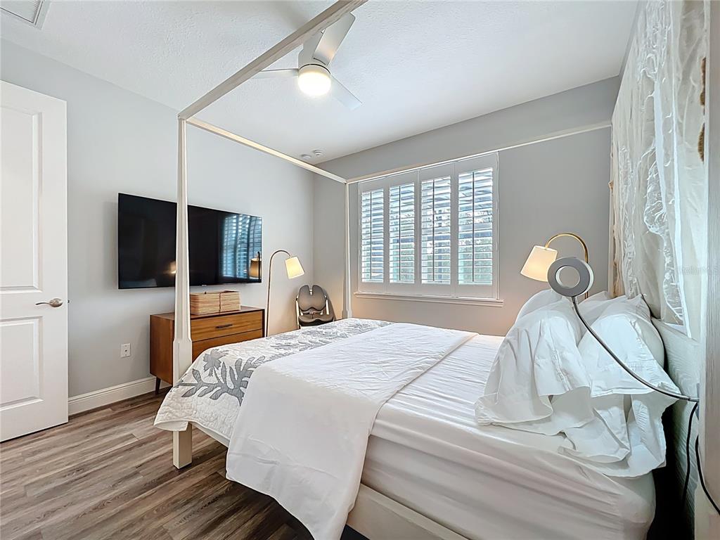 10220 Bay Lake Road Groveland, FL 34736 - Photo 73 of 90 a bedroom with a bed and a flat tv screen on dresser