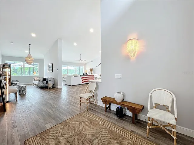 a large kitchen with kitchen island a stove a table a sink a refrigerator and a dining table