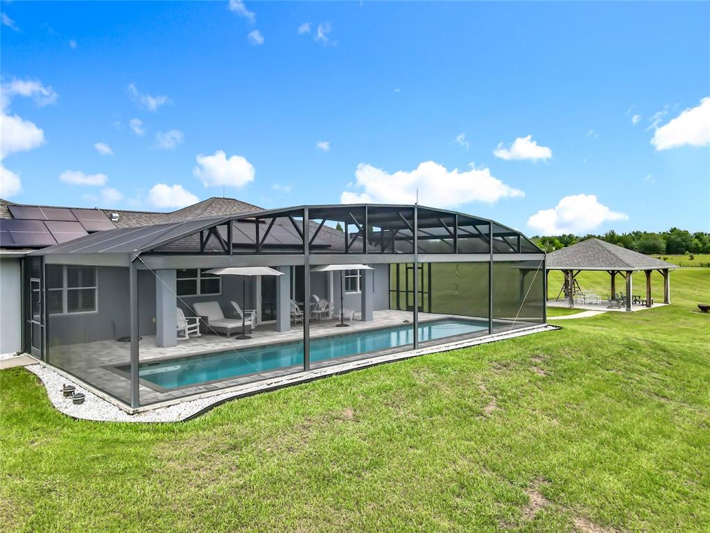 10220 Bay Lake Road Groveland, FL 34736 - Photo 81 of 90 a view of a house with a backyard porch and sitting area
