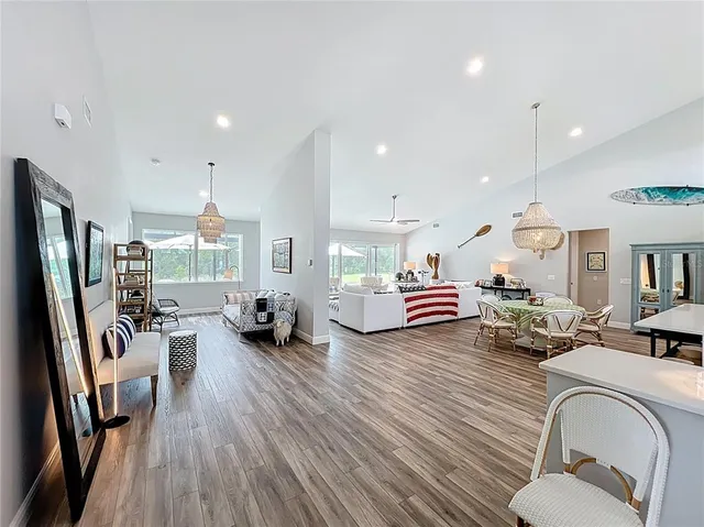 a view of a dining room with furniture a chandelier and wooden floor