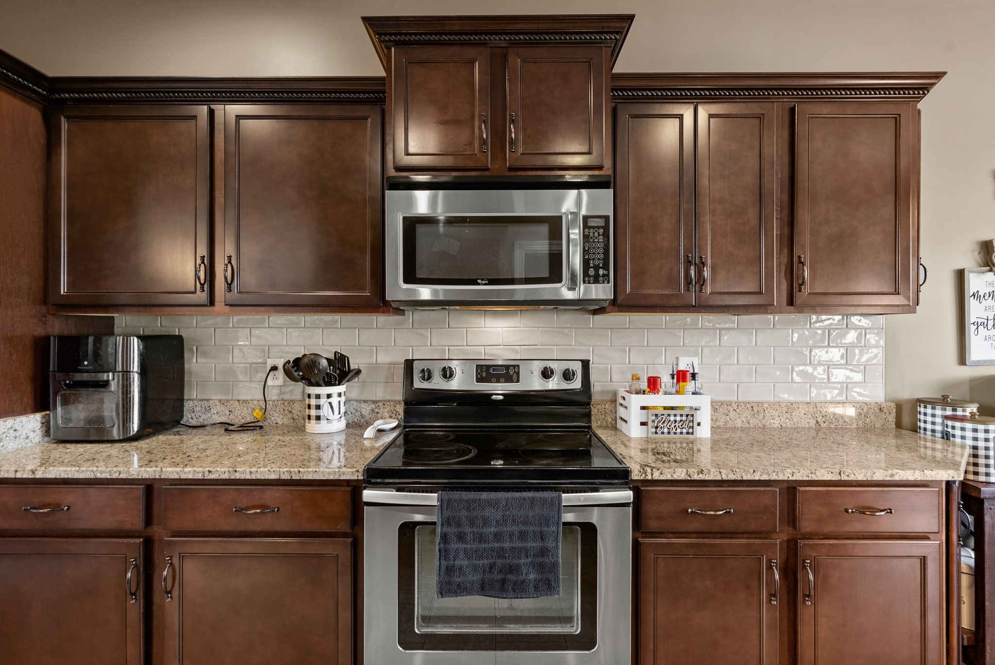 1192 Wicke Road Adams, TN 37010 - Photo 21 of 45 a kitchen with granite countertop a stove top oven microwave and cabinets