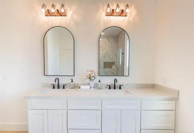 a bathroom with double vanity sinks and a mirror