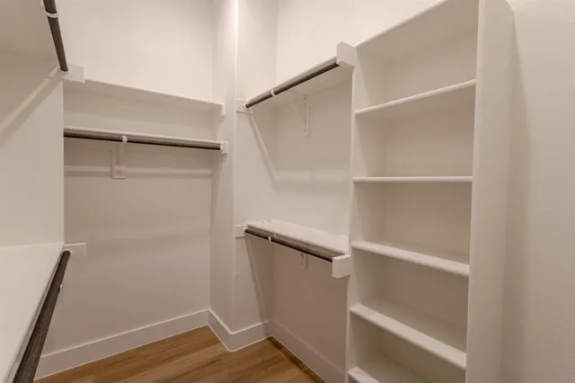 a view of walk in closet with empty racks
