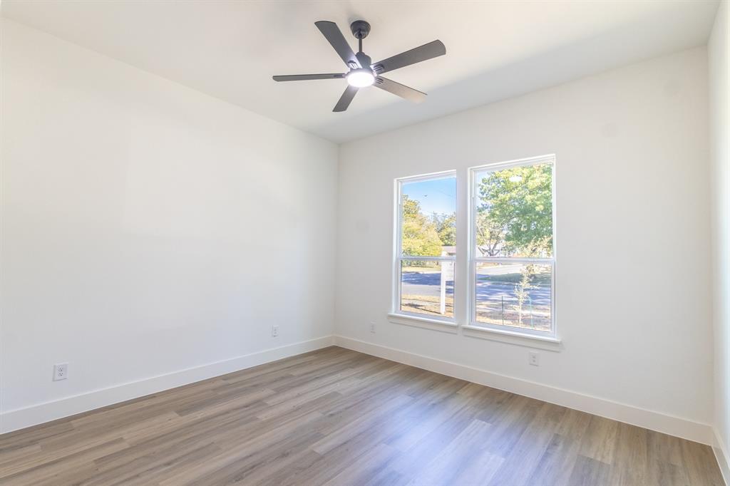 2900 8th Avenue Fort Worth, TX 76110 - Photo 14 of 32 an empty room with wooden floor and windows