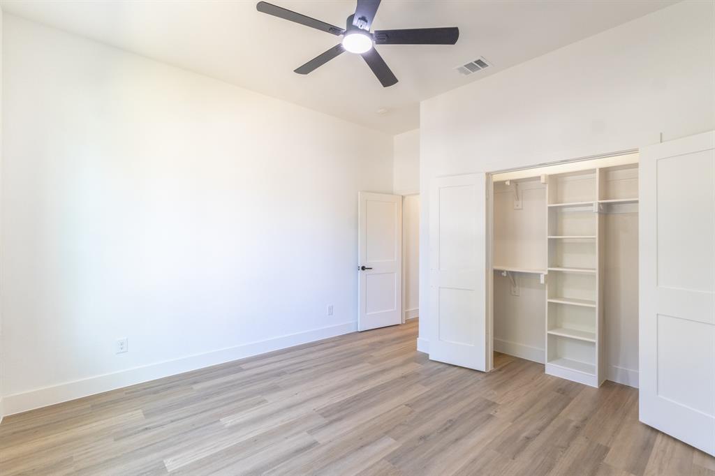 2900 8th Avenue Fort Worth, TX 76110 - Photo 15 of 32 a view of a room with wooden floor and ceiling fan