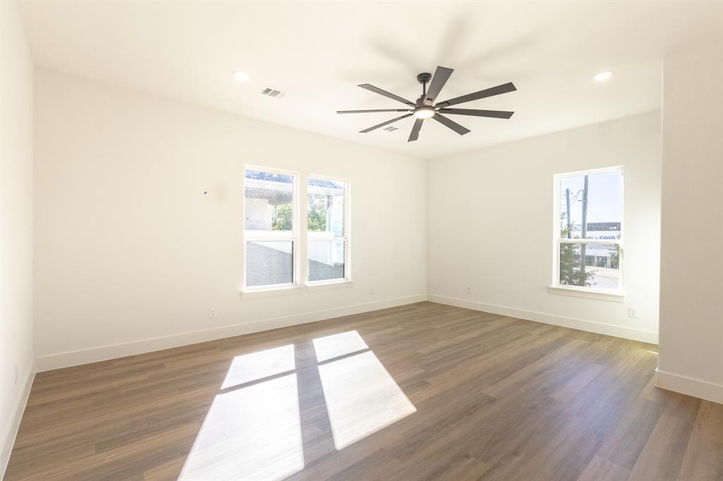 2900 8th Avenue Fort Worth, TX 76110 - Photo 20 of 32 a view of an empty room with wooden floor and a window
