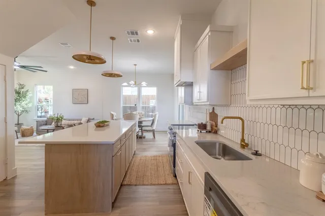 a large kitchen with kitchen island a sink a counter space and stainless steel appliances