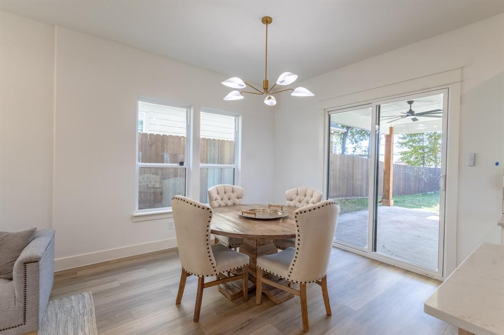 2900 8th Avenue Fort Worth, TX 76110 - Photo 7 of 32 a dining room with furniture a chandelier and wooden floor