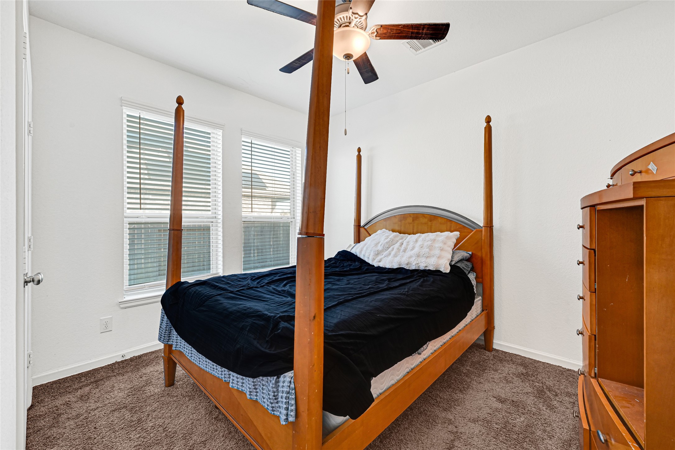 4307 Annandale Lane Rosharon, TX 77583 - Photo 24 of 31 This first floor bedroom in the private apartment features room for a four-poster bed and dresser. It provides soft carpeting, and ample natural light from well-placed windows. A ceiling fan adds comfort.