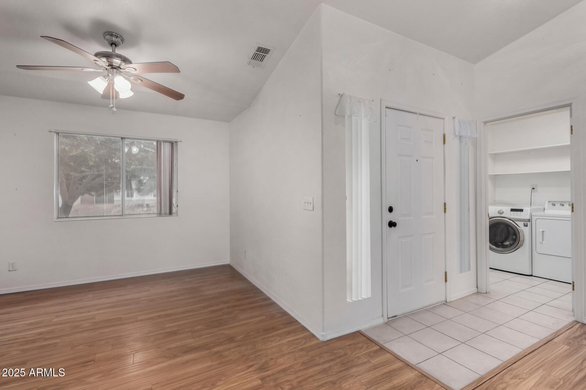 1794 West 11th Avenue Apache Junction, AZ 85120 - Photo 14 of 33 an empty room with wooden floor chandelier fan and windows