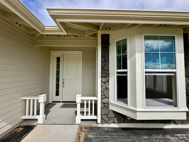 a view of a hallway with wooden floor and a bathroom
