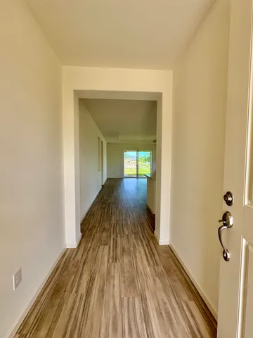 a large kitchen with stainless steel appliances granite countertop a stove a sink a refrigerator white cabinets and wooden floor