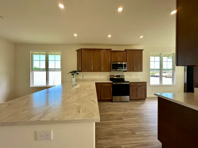 a kitchen with granite countertop a stove a sink and a microwave