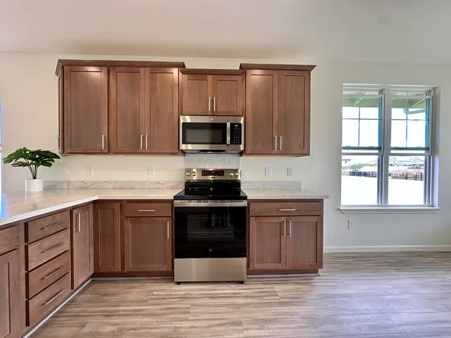 a kitchen with stainless steel appliances a stove microwave and a refrigerator