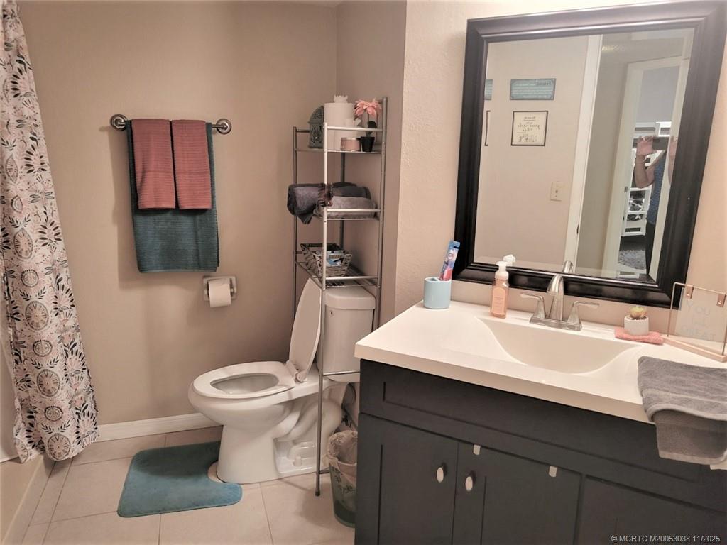 1526 Southeast Royal Green Circle, Unit 205 Port St. Lucie, FL 34952 - Photo 19 of 34 a bathroom with a sink toilet and mirror