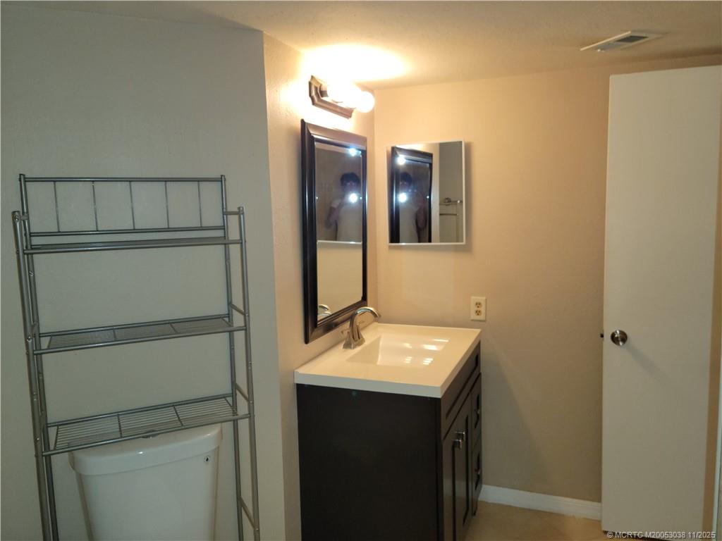 1526 Southeast Royal Green Circle, Unit 205 Port St. Lucie, FL 34952 - Photo 20 of 34 a bathroom with a sink and a mirror