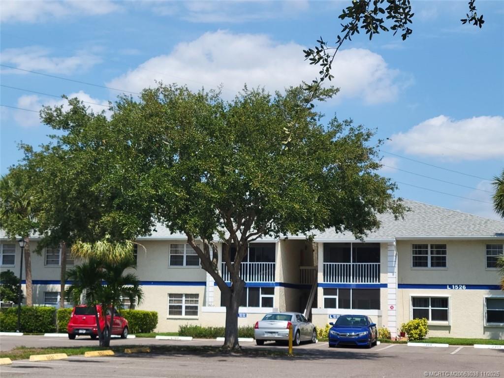 1526 Southeast Royal Green Circle, Unit 205 Port St. Lucie, FL 34952 - Photo 2 of 34 a view of a cars parked in front of a building