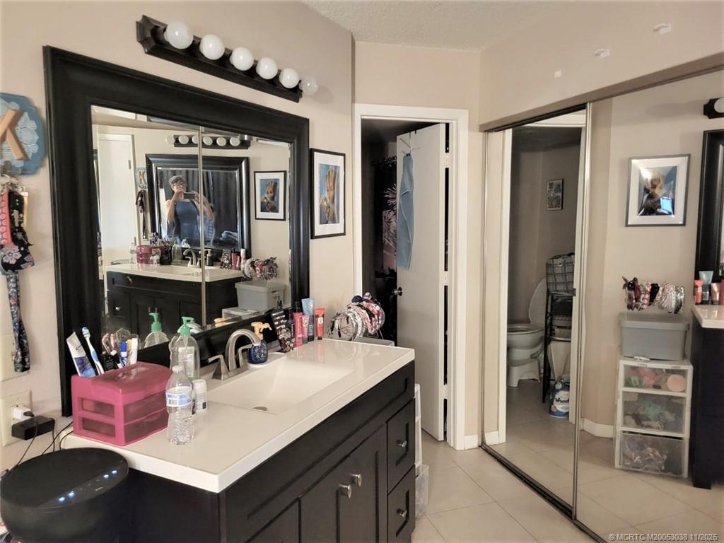 1526 Southeast Royal Green Circle, Unit 205 Port St. Lucie, FL 34952 - Photo 26 of 34 a bathroom with a sink vanity and a mirror