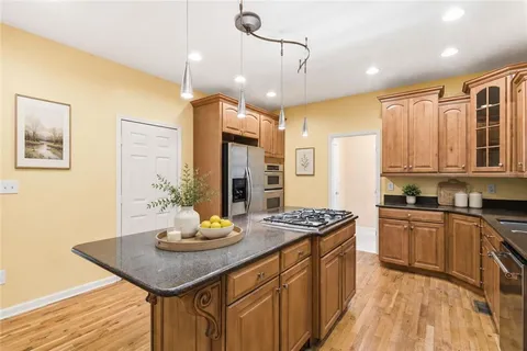 a kitchen with stainless steel appliances a sink a stove a refrigerator and cabinets