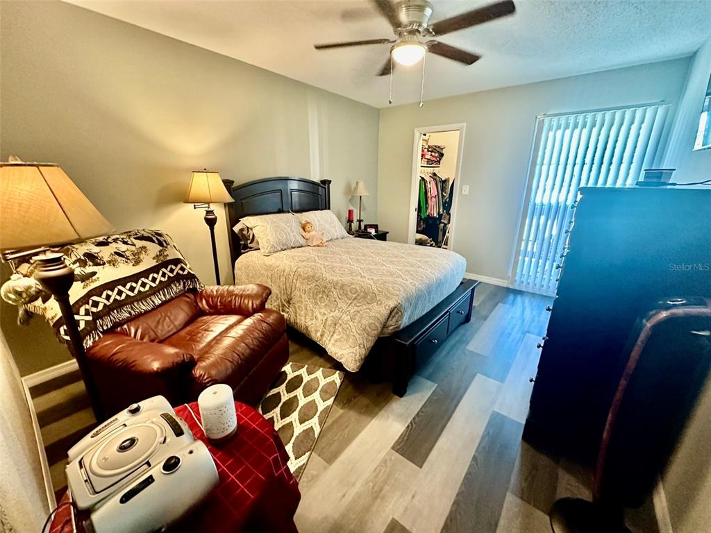 5207 Turquoise Lane, Unit 202 New Port Richey, FL 34652 - Photo 13 of 26 a bedroom with two beds and a chandelier