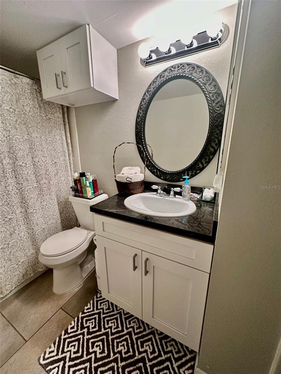 5207 Turquoise Lane, Unit 202 New Port Richey, FL 34652 - Photo 15 of 26 a bathroom with a toilet a sink and a mirror
